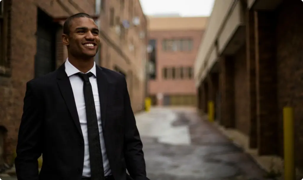 Happy man in suit walking through buildings